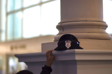 A police officer rests her hat atop a column while using her phone at the 2017 "Congress of Tomorrow" Joint Republican Issues Conference in Philadelphia, Pennsylvania, U.S. January 27, 2017. REUTERS/Mark Makela