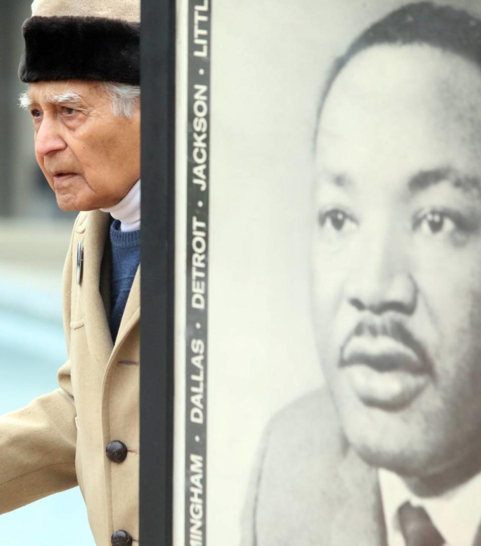 Sudarshan Kapoor stands next to a poster of Martin Luther King Jr. prior to the start of the MLK Unity March in downtown Fresno on Jan. 15, 2024.