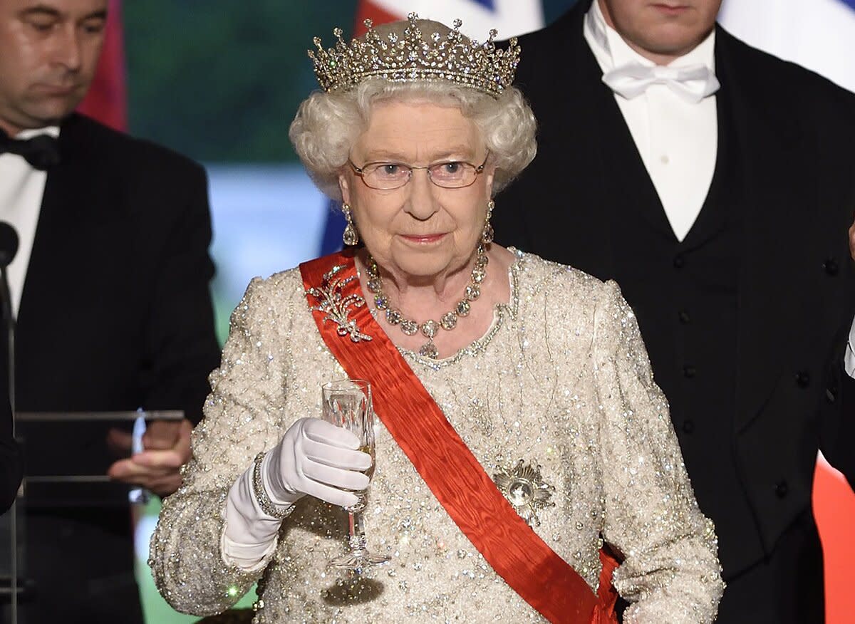 Britain's Queen Elizabeth II, French President Francois Hollande (R) and French Prime Minister Manuel Valls make a toast at a state dinner at the Elysee presidential palace in Paris, following the international D-Day commemoration