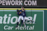 Seattle Mariners center fielder Julio Rodriguez, left, and right fielder Mitch Haniger collide at the wall while trying to catch a fly ball from Los Angeles Angels' Luis Rengifo during the first inning of a baseball game Monday, Aug. 15, 2022, in Anaheim, Calif. Rengifo was awarded a solo home run on the play. (AP Photo/Marcio Jose Sanchez)