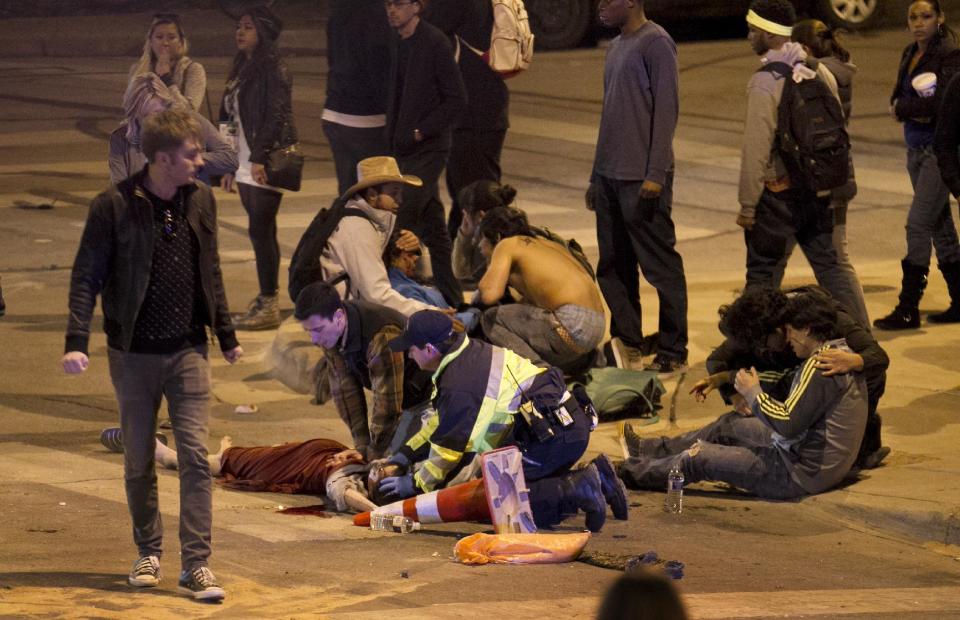 People are treated after being struck by a vehicle on Red River Street in downtown Austin, Texas, during SXSW on Wednesday March 12, 2014. Police say two people were confirmed dead at the scene after a car drove through temporary barricades set up for the South By Southwest festival and struck a crowd of pedestrians. (AP Photo/Austin American-Statesman, Jay Janner)