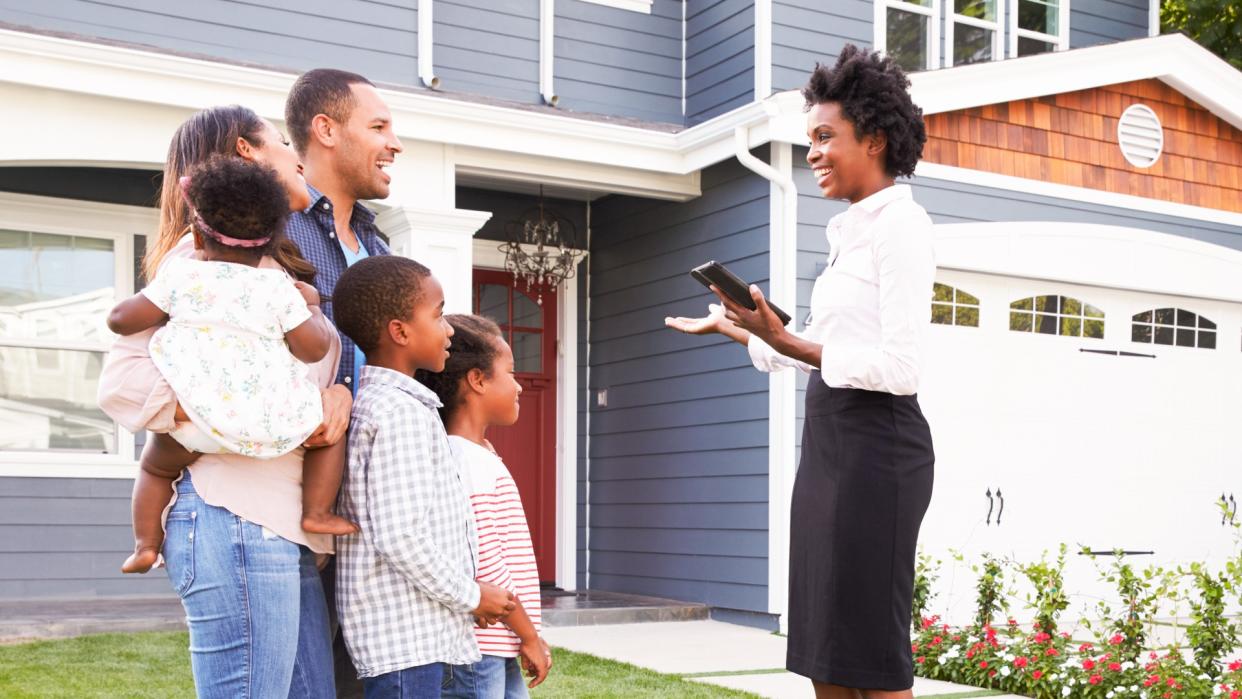 Real estate agent showing a family a house.