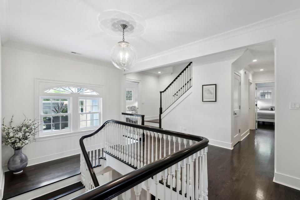 An upstairs with dark floors and banisters.