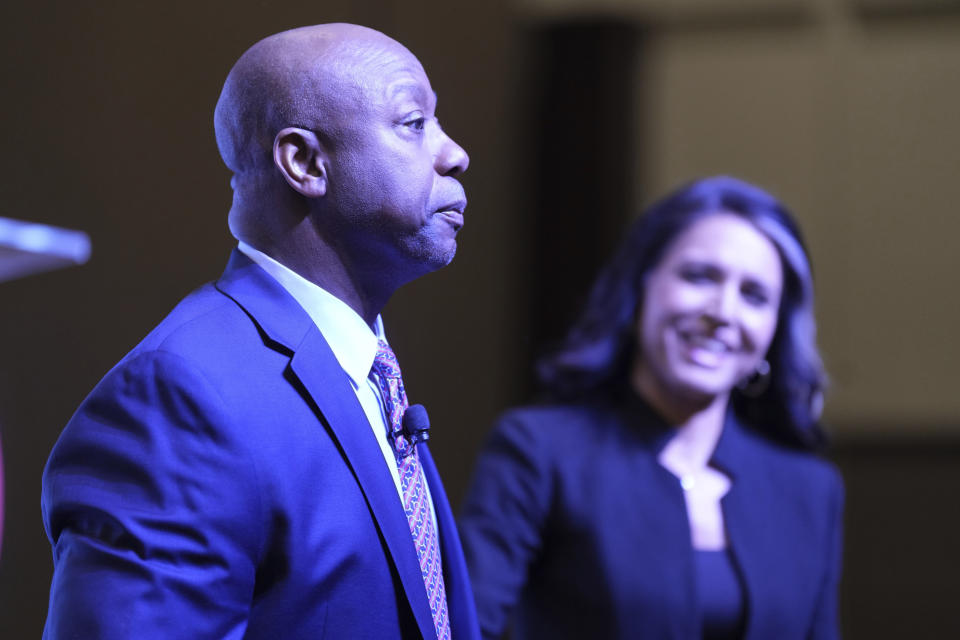 Former Rep. Tulsi Gabbard of Hawaii, right, looks on as Sen. Tim Scott, R-S.C., thanks her for her support following the Mother Emanuel AME church shootings, before he speaks at the Vision '24 conference on Saturday, March 18, 2023, in North Charleston, S.C. Presidential contenders Nikki Haley and Vivek Ramaswamy are among the Republicans speaking at the event, expected to take on "woke ideology." (AP Photo/Meg Kinnard)