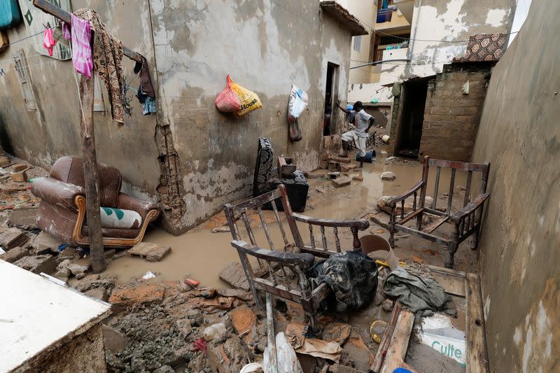 A man stands at a house's flooded courtyard after heavy rains in the Ndiaga Mbaye district on the outskirts of Dakar