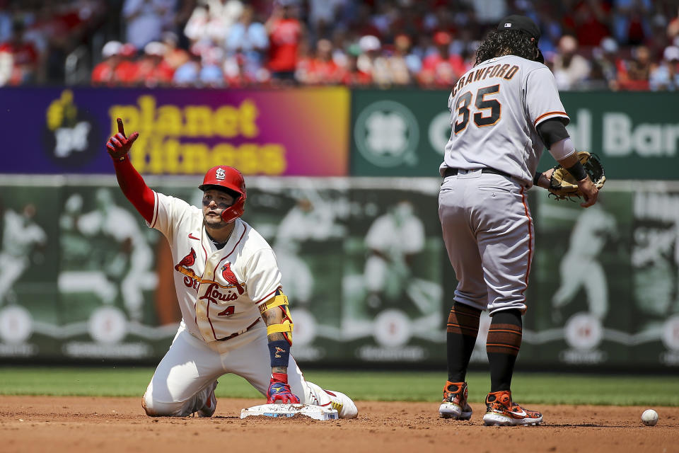 San Francisco Giants shortstop Brandon Crawford (35) stands near as St. Louis Cardinals' Yadier Molina gestures toward the dugout after hitting a double during the second inning of a baseball game Saturday, May 14, 2022, in St. Louis. (AP Photo/Scott Kane)