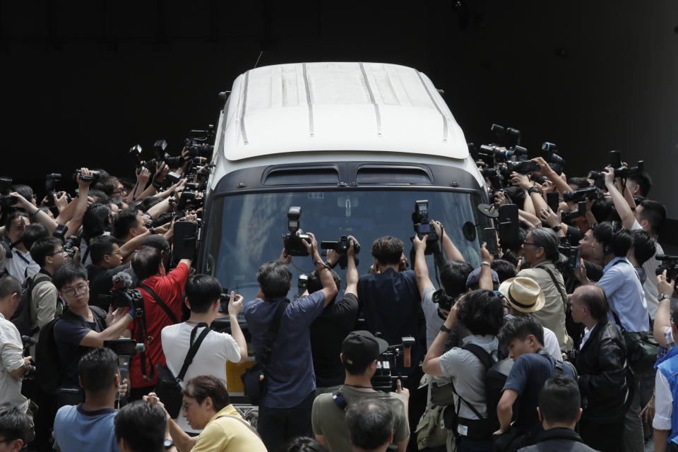 In this April 24, 2019, file photo, photographers scramble around a prison van carrying the Occupy Central leaders Chan Kin-man, Benny Tai, Raphael Wong and Shiu Ka-chun at a court in Hong Kong. (AP Photo/Kin Cheung, File)