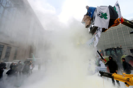 Milk producers spray powdered milk to protest against dairy market overcapacity outside a meeting of European Union agriculture ministers in Brussels, Belgium, January 23, 2017. REUTERS/Francois Lenoir