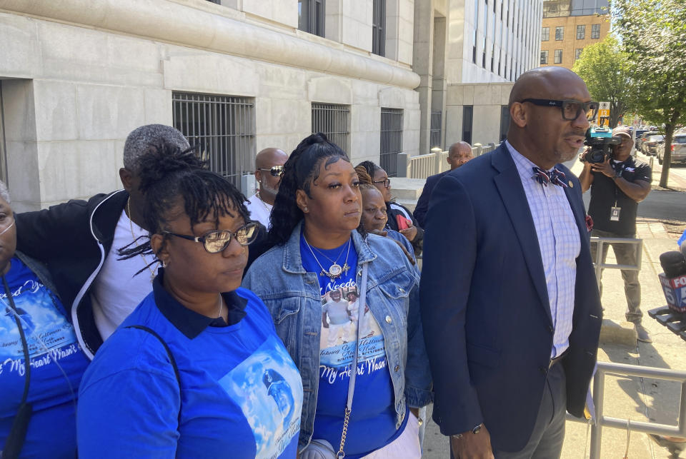 Attorney Mawuli Davis, right, speaks to reporters, Monday, Oct. 9, 2023, outside the Fulton County courthouse in Atlanta, while flanked by relatives of Johnny Holman Sr. Davis says an Atlanta police video showing events leading to Hollman's Aug. 10, death during a traffic stop is likely to be released in coming days. (AP Photo/Jeff Amy)