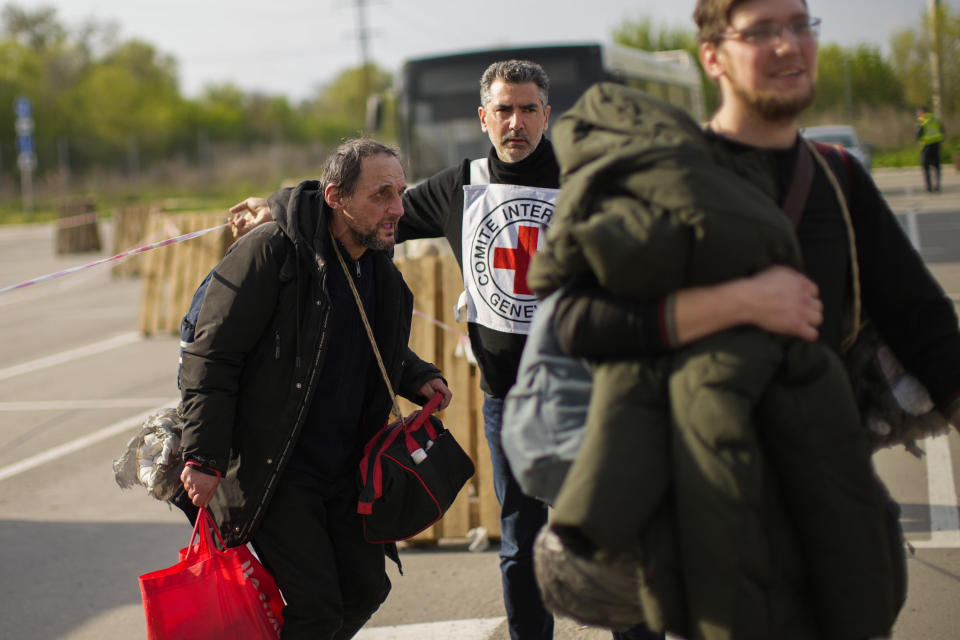 Serhii Tsybulchenko, left, and his son-in-law Ihor Trotsak, right, who fled with their family from the Azovstal steel plant in Mariupol, arrive to a reception center for displaced people in Zaporizhzhia, Ukraine, Tuesday, May 3, 2022. The Tsybulchenko family was among the first to emerge from the steel plant in a tense, days-long evacuation negotiated by the United Nations and the International Committee of the Red Cross with the governments of Russia, which now controls Mariupol, and Ukraine, which wants the city back. A brief cease-fire allowed more than 100 civilians to flee the plant. (AP Photo/Francisco Seco)