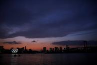 The giant Olympic rings are seen in the dusk at the waterfront area at Odaiba Marine Park in Tokyo