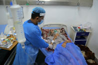 A coronavirus patient receives treatment at a hospital in Najaf, Iraq, Wednesday, July 14, 2021. Infections in Iraq have surged to record highs amid a third wave spurred by the more aggressive delta variant, and long-neglected hospitals suffering the effects of decades of war are overwhelmed with severely ill patients. (AP Photo/Anmar Khalil)