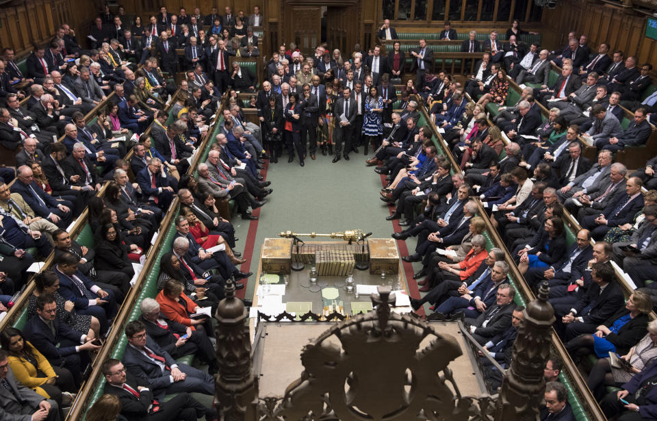 Britain's Prime Minister Theresa May sits on front bench right, orange jacket, facing a packed parliament Tuesday March 12, 2019. May keeps going, declining to resign, despite two successive parliamentary defeats of historic proportion and she is still pushing for her Brexit agreement, despite ample evidence that Parliament won’t support it. (Mark Duffy/UK Parliament via AP)