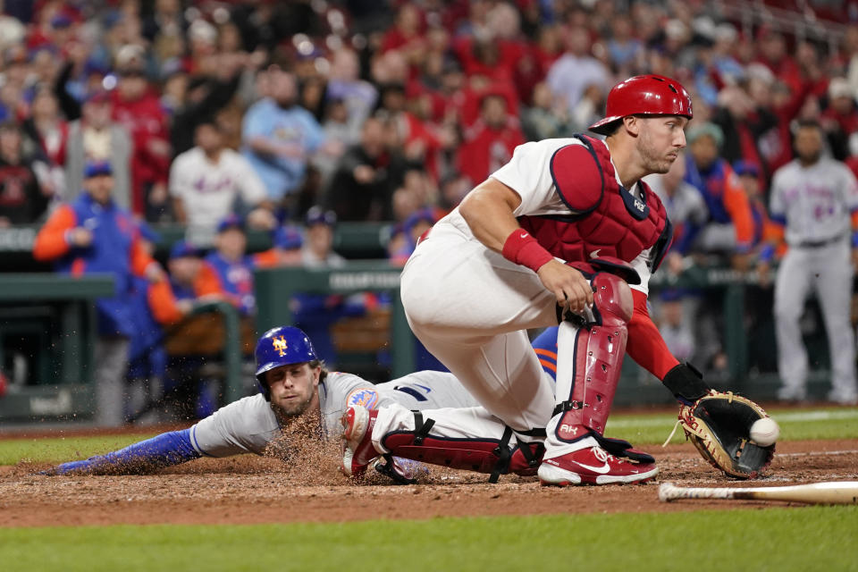 CORRECTS TO METS' JEFF MCNEIL NOT TRAVIS JANKOWSKI - New York Mets' Jeff McNeil, left, scores past St. Louis Cardinals catcher Andrew Knizner during the ninth inning of a baseball game Monday, April 25, 2022, in St. Louis. (AP Photo/Jeff Roberson)