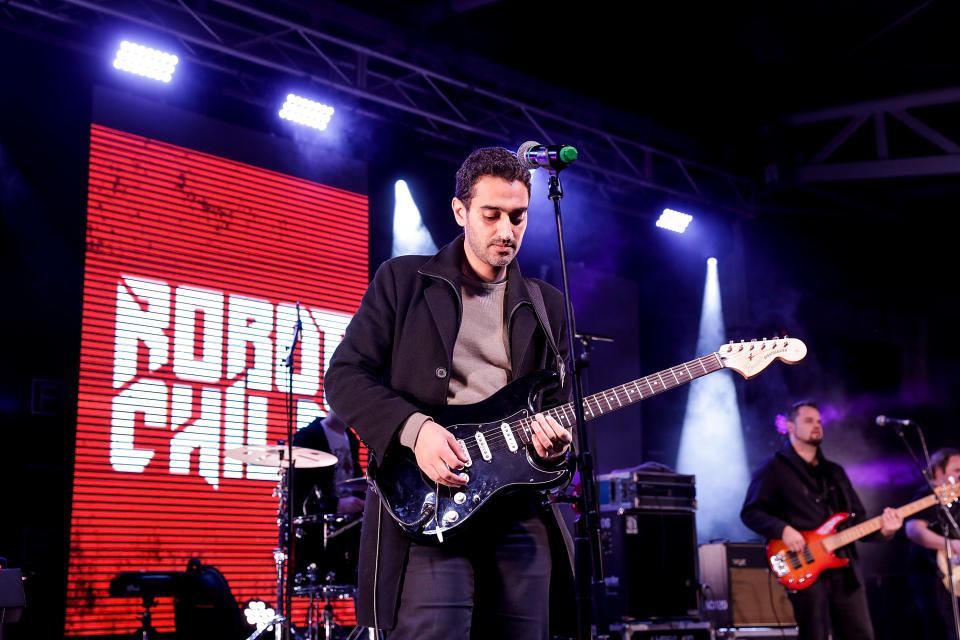 A photo of The Project presenter Waleed Aly playing guitar with his band Robot Child at the Winter Solstice Festival Of Welcome at Federation Square in Melbourne, Australia on June 24, 2017.