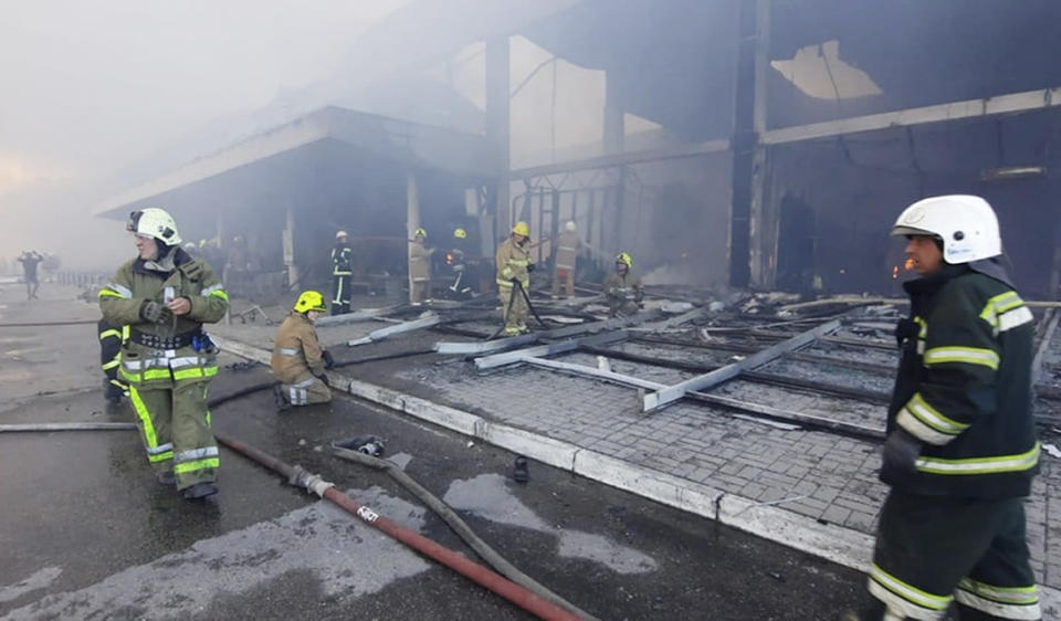 En una imagen tomada de un video proporcionado por el Servicio Estatal de Emergencias de Ucrania, bomberos tratan de extinguir las llamas en un centro comercial que fue impactado por un misil, el lunes 27 de junio de 2022, en Kremenchuk, Ucrania. (Servicio Estatal de Emergencias de Ucrania vía AP)