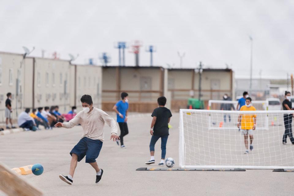 Migrant youths play soccer at the Cotton Logistics oilfield housing that was constructed in 2012 to temporarily house workers in the oil industry in Midland, Texas on April 5, 2021.  / Credit: ADREES LATIF / REUTERS