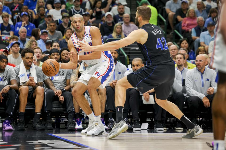 Philadelphia 76ers forward Nicolas Batum (40) passes as he falls out of bounds while being defended by Dallas Mavericks forward Maxi Kleber (42) during the first half of an NBA basketball game, Sunday, March 3, 2024, in Dallas. (AP Photo/Gareth Patterson)