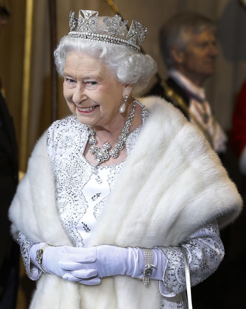 Queen Elizabeth II smiles as she leaves the State Opening of Parliament in 2013.