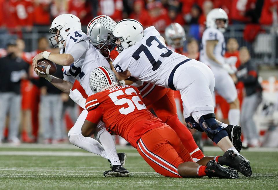 Ohio State defensive tackle Antwuan Jackson (52) has 2.5 sacks this season. Here he and linebacker Palaie Gaoteote take down Penn State quarterback Sean Clifford.