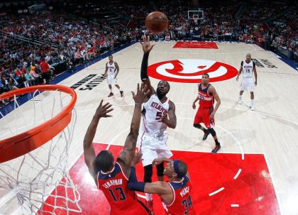 DeMarre Carroll lofts a floater over Kevin Seraphin and Paul Pierce. (Kevin C. Cox/Getty Images)