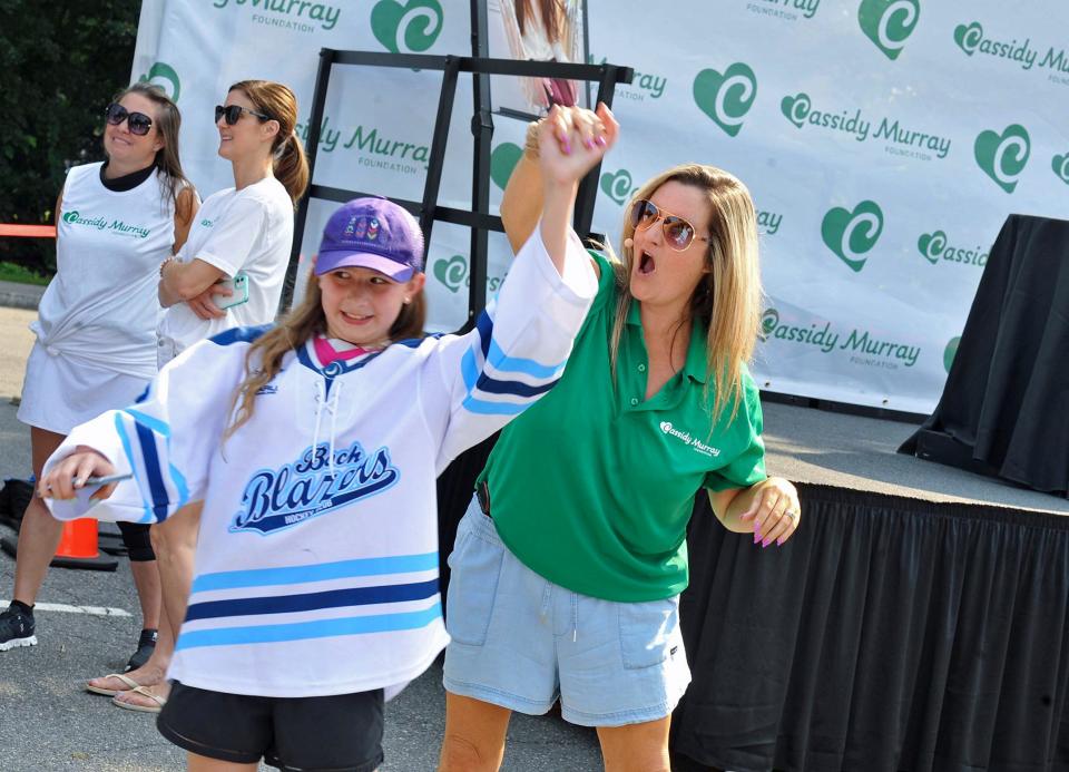 Morgan Emerson, left, and Mel Gillespie, right, both of Milton, dance during the launching of the Cassidy Murray Foundation in Milton, which featured a visit by the Stanley Cup on Thursday, July 13, 2023.