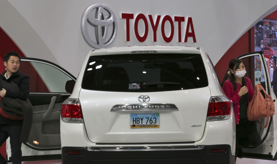 Visitors inspect a car on display at Toyota gallery in Tokyo Tuesday, Feb. 4, 2014. Toyota Motor Corp. reported a more than fivefold jump in its quarterly profit Tuesday and raised its earnings forecast, crediting a weak yen and strong sales. Toyota's profit for the October-December quarter totaled a better-than-expected 525.4 billion yen ($5.2 billion), up dramatically from 99.9 billion yen a year earlier. (AP Photo/Koji Sasahara)