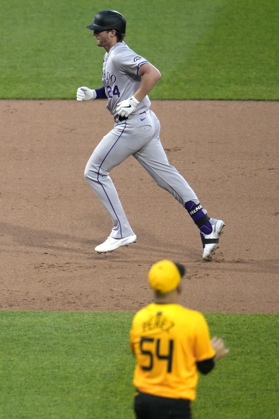 Colorado Rockies' Ryan McMahon (24) rounds the bases after hitting a solo home run off Pittsburgh Pirates starting pitcher Martín Pérez (54) during the sixth inning of a baseball game in Pittsburgh, Friday, May 3, 2024. (AP Photo/Gene J. Puskar)