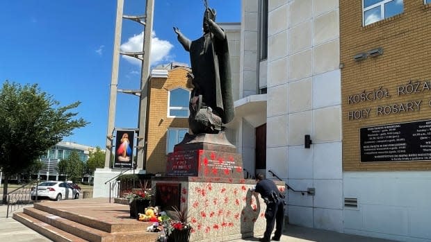 A statue of Pope John Paul II, who was elected as Pope in 1978, located outside an Edmonton church was painted red Saturday night, police say. (Tricia Kindleman/CBC - image credit)