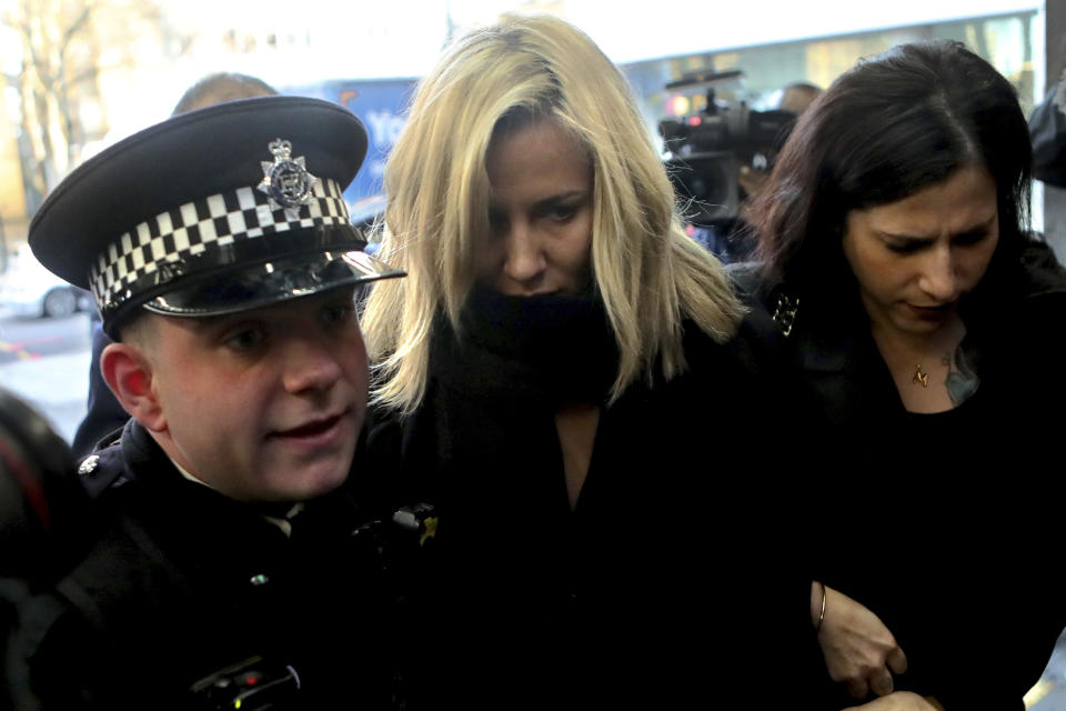 Love Island TV presenter Caroline Flack, centre, escorted by police, as she arrives at Highbury Magistrates' Court in London, Monday, Dec. 23, 2019.  Flack has stepped down as host of the upcoming winter series of the TV dating show, Love Island, after being charged with assault of former professional tennis player and model Burton. (AP Photo/Petros Karadjias)