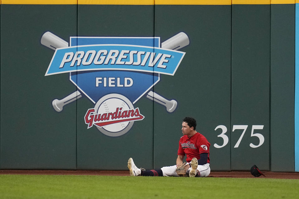 Cleveland Guardians right fielder Will Brennan sits on the warning track after catching a fly ball hit by Los Angeles Dodgers' Freddie Freeman during the fifth inning of a baseball game Tuesday, Aug. 22, 2023, in Cleveland. (AP Photo/Sue Ogrocki)