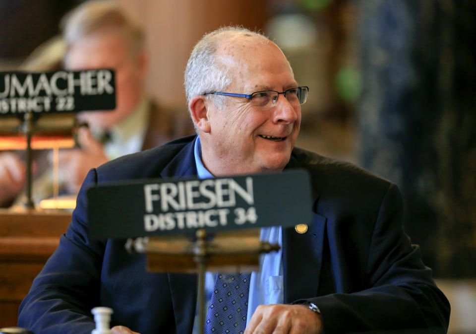 FILE- In this Jan. 8, 2018 file photo, Neb. State Sen. Curt Friesen smiles at his desk, in the Legislative Chamber in Lincoln, Neb. Nebraska ranks sixth nationally in the number of recall elections held over the last decade, adjusting for the state's small population. Under a bill proposed by Friesen, voters will lose the power to boot Nebraska mayors, county commissioners or school board members out of office before their terms end. Friesen says frequent recall elections in Nebraska could discourage good candidates from seeking public office. (AP Photo/Nati Harnik, File)