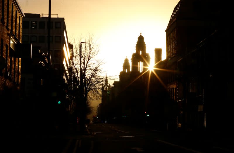 The sun sets behind Belfast City Hall