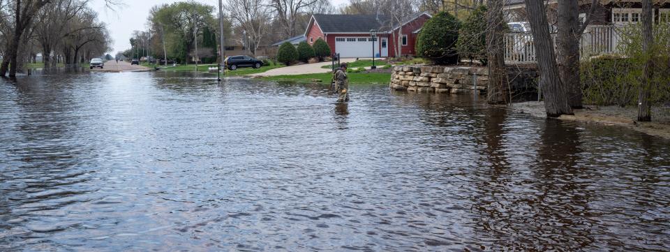 A man walks through floodwaters to a home along the Mississippi River on April 27 in the Town of Campbell, just outside La Crosse.