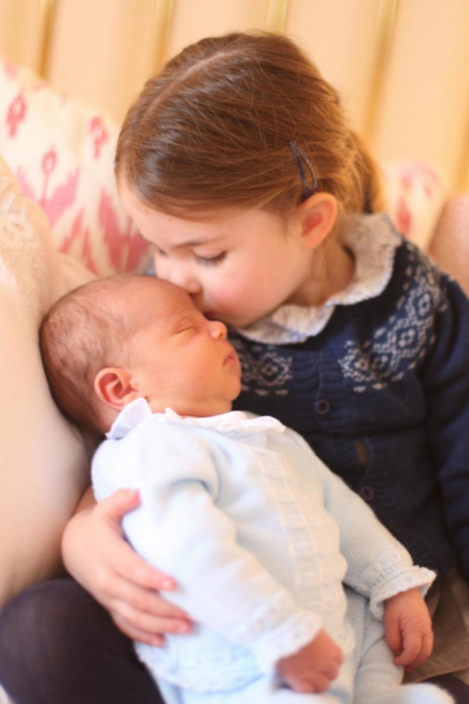 Princess Charlotte plants a kiss on her newborn baby brother Prince Louis in this adorable snap taken by their mother (PA)