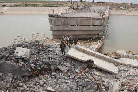 Kurdish Peshmerga forces inspect a bridge that was destroyed by Islamic State militants on the outskirts of Kirkuk March 12, 2015. REUTERS/Ako Rasheed