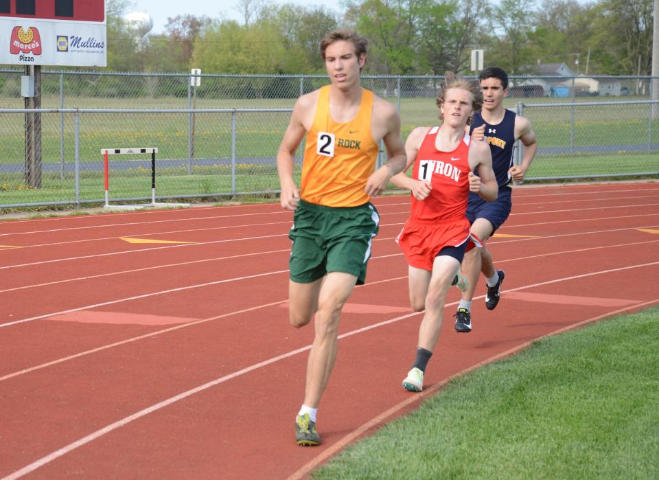 Kenny Carlman of Flat Rock, New Boston Huron’s Griffin Mentzer and Jacob Perez of Airport (left to right) battle for the lead in the boys 1,600 meters Tuesday. Mentzer won the race with Carlman second and Perez third.