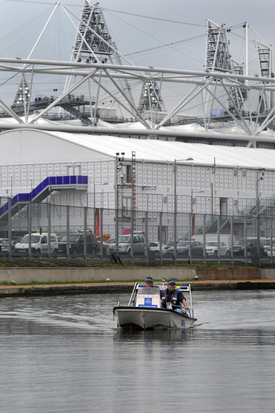 Constable Neil Baker, left, and Constable Dan Collins from the Metropolitan police Marine Unit patrol the canal waterway around the perimeter of the Olympic Stadium in Stratford, east London Friday July 20, 2012. (AP Photo/Anthony Devlin, Pool)