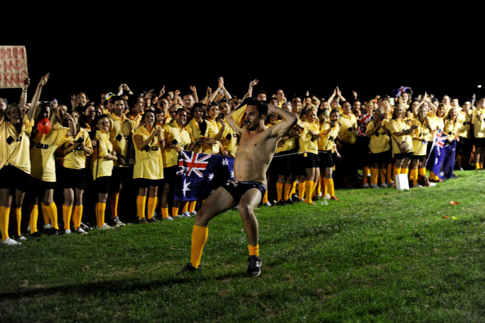 A man runs in his underwear past over 1000 Australian fans spelling out the word G'Day on Clapham Common in London, Wednesday, July 25, 2012. The fans attempted to break the Guinness World record for The Most People Wearing The Same Full Team Kit.