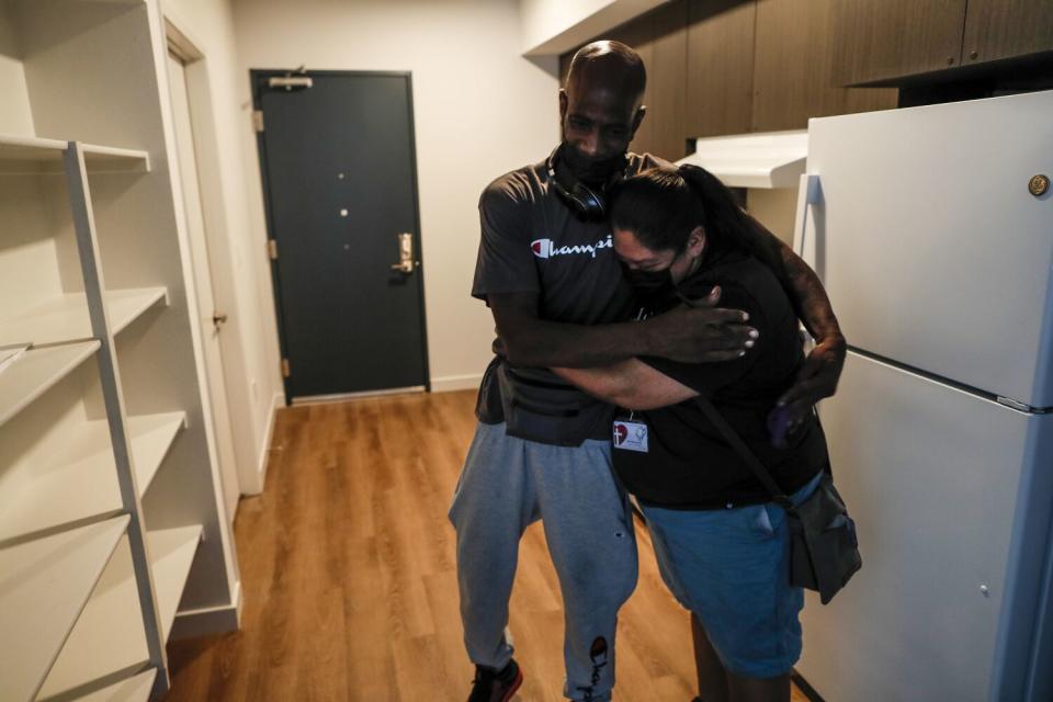 L.A. Christian Health Center Housing coordinator Ruth Morquecho embraces Donald Winston