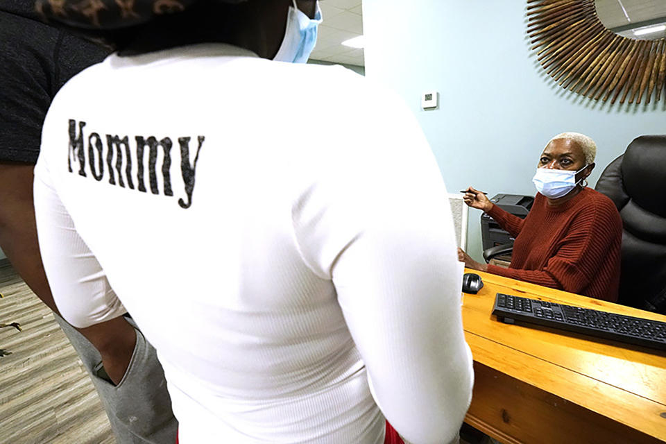 A patient speaks with receptionist and office assistant Mattie Nichols, right, at Sisters in Birth, a Jackson, Miss., clinic that serves pregnant women, Dec. 17, 2021. (AP Photo/Rogelio V. Solis)