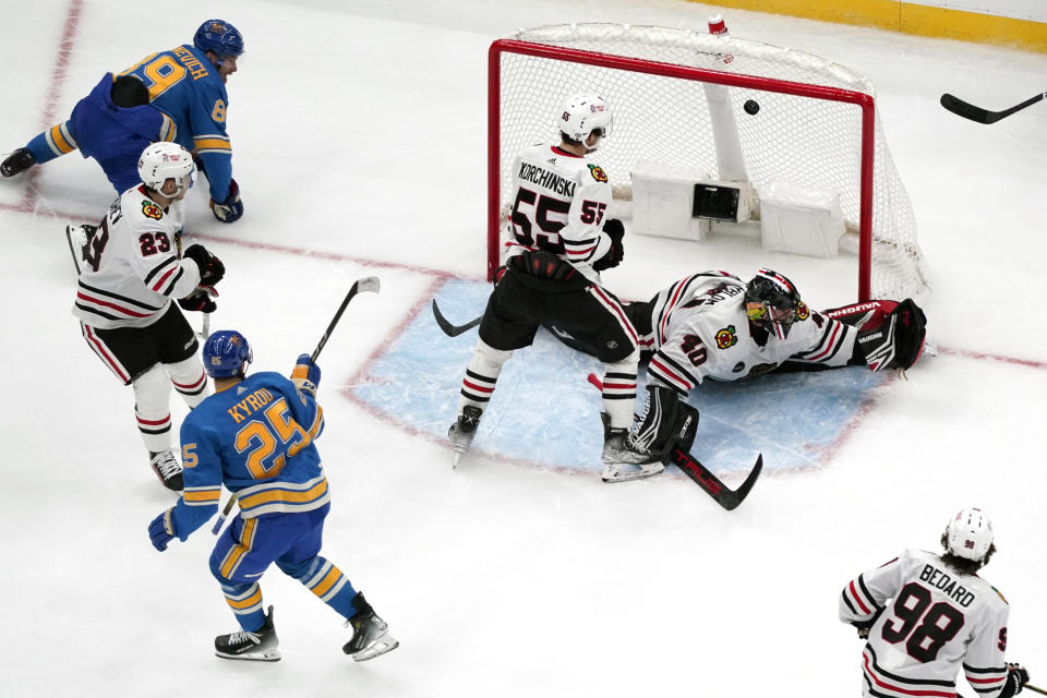 St. Louis Blues' Jordan Kyrou (25) scores past Chicago Blackhawks goaltender Arvid Soderblom (40) and Kevin Korchinski (55) during the third period of an NHL hockey game Saturday, Dec. 23, 2023, in St. Louis. (AP Photo/Jeff Roberson)