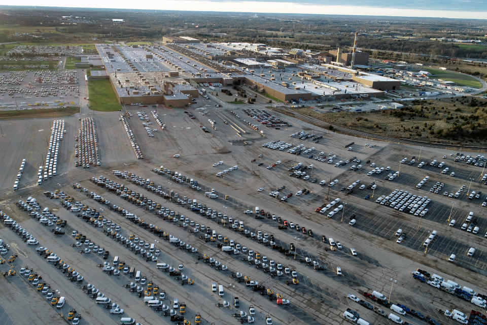 FILE - In this aerial photo, a General Motors assembly plant is seen at top right while mid-sized pickup trucks and full-size vans currently produced at the plant are seen in a parking lot outside Wednesday, March 24, 2021, in Wentzville, Mo. Experts say unless more spending shifts back to services or something else motivates people to stop buying, it could take well into next year or even 2023 before the U.S. and global supply chains return to some semblance of normal. (AP Photo/Jeff Roberson, File)