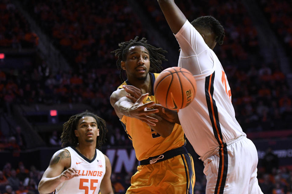 UMKC's Shemarri Allen (5) passes the ball around Illinois' Dain Dainja as Illinois' Skyy Clark watches during the second half of an NCAA college basketball game Friday, Nov. 11, 2022, in Champaign, Ill. (AP Photo/Michael Allio)