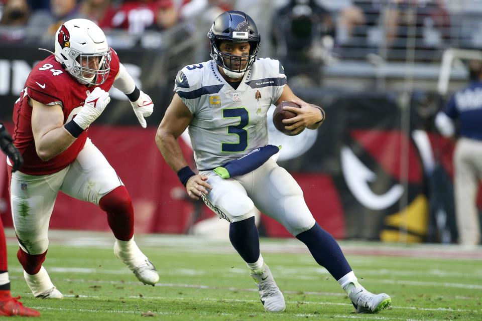 Seattle Seahawks quarterback Russell Wilson (3) runs with the ball as Arizona Cardinals defensive end Zach Allen (94) gives chase during the first half of an NFL football game Sunday, Jan. 9, 2022, in Glendale, Ariz. (AP Photo/Ralph Freso)