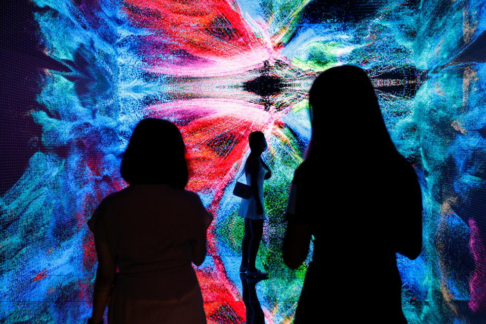 Visitors are pictured in front of an immersive art installation titled 