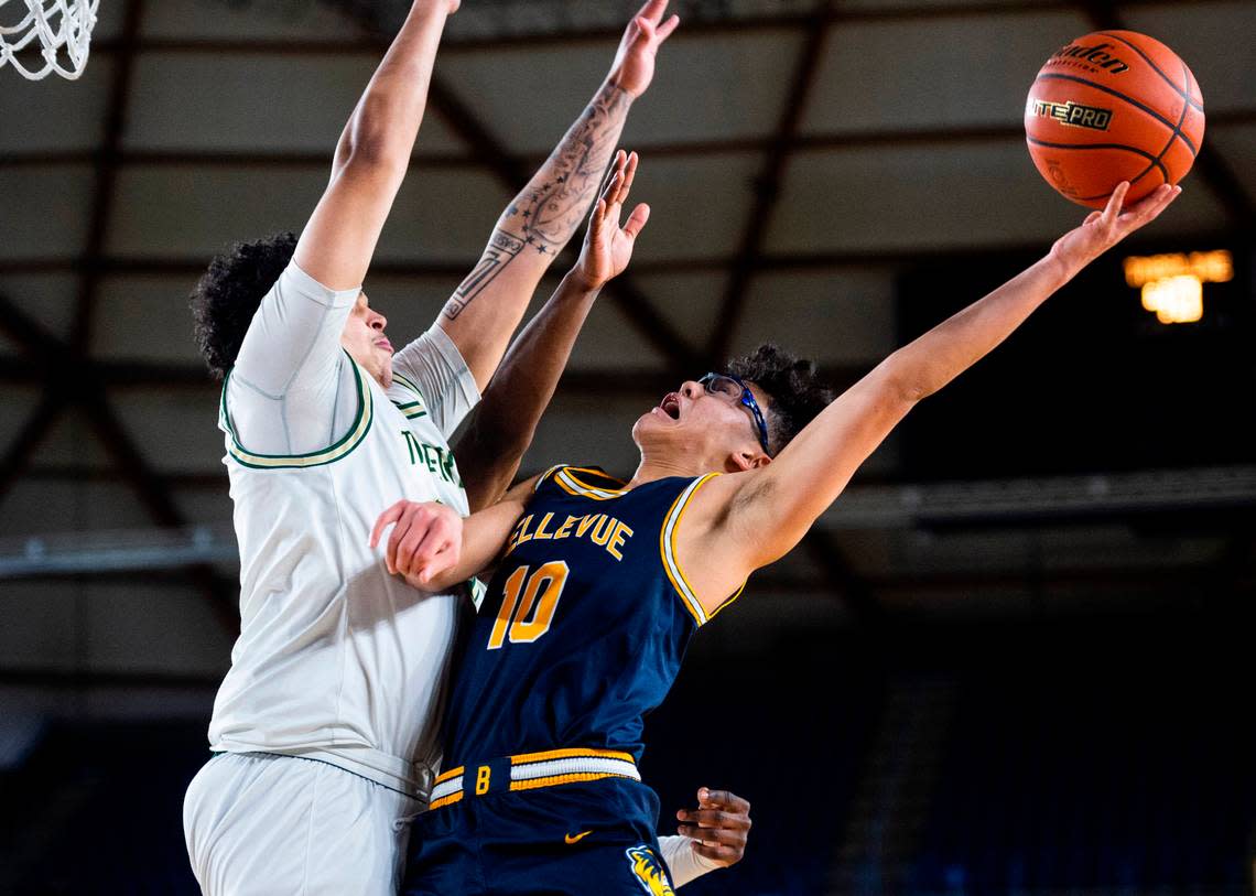 Bellevue guard Brady Kageyama (10) jumps to shoot a layup as Timberline forward Devin Wilson (33) tries to block him during an opening round game at the WIAA state basketball tournament in the Tacoma Dome in Tacoma, Washington, on Wednesday, March 1, 2023. Timberline lost the game 49-52.