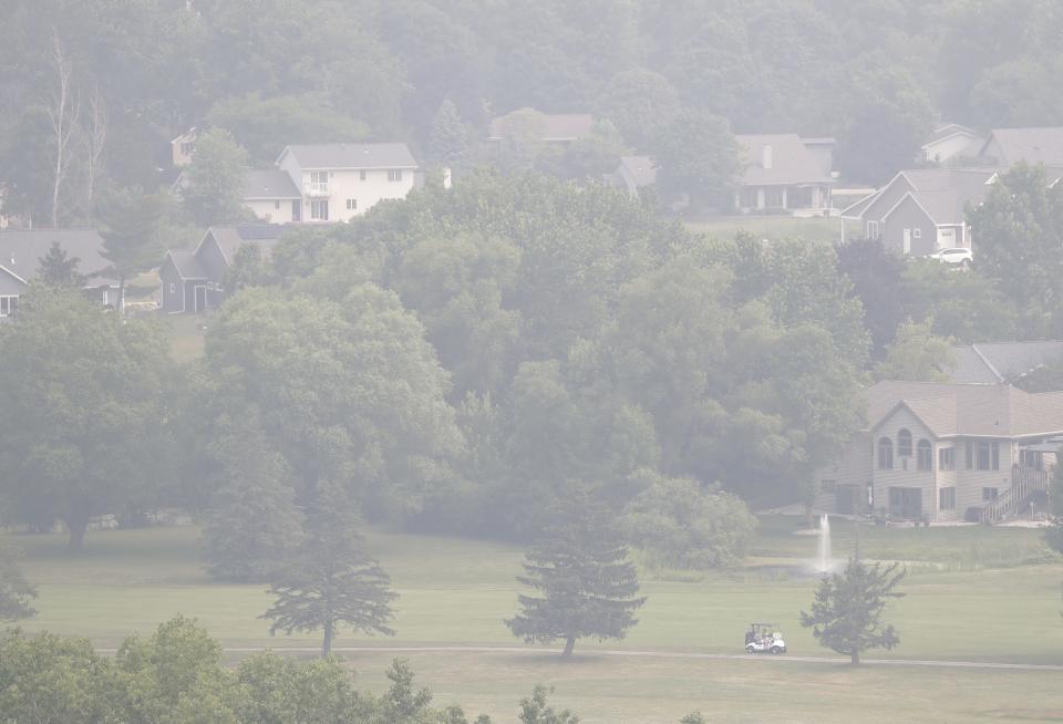 Golfers make their way to a green under a blanket of haze Tuesday, June 27, 2023, at the High Cliff Golf and Event Center in Sherwood, Wis. 
Dan Powers/USA TODAY NETWORK-Wisconsin.