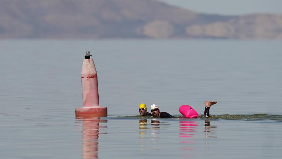 Two men swim in the Great Salt Lake on Saturday, April 15, 2023, in Magna, Utah. Open-water swimmers are among those rejoicing after the winter's snow melted and increased the lake's elevation beyond last year's record low. (AP Photo/Rick Bowmer)