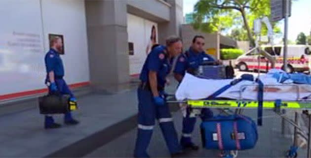 Ambulance staff take the woman away from The Cosmetic Institute in Parramatta. Photo: 7News